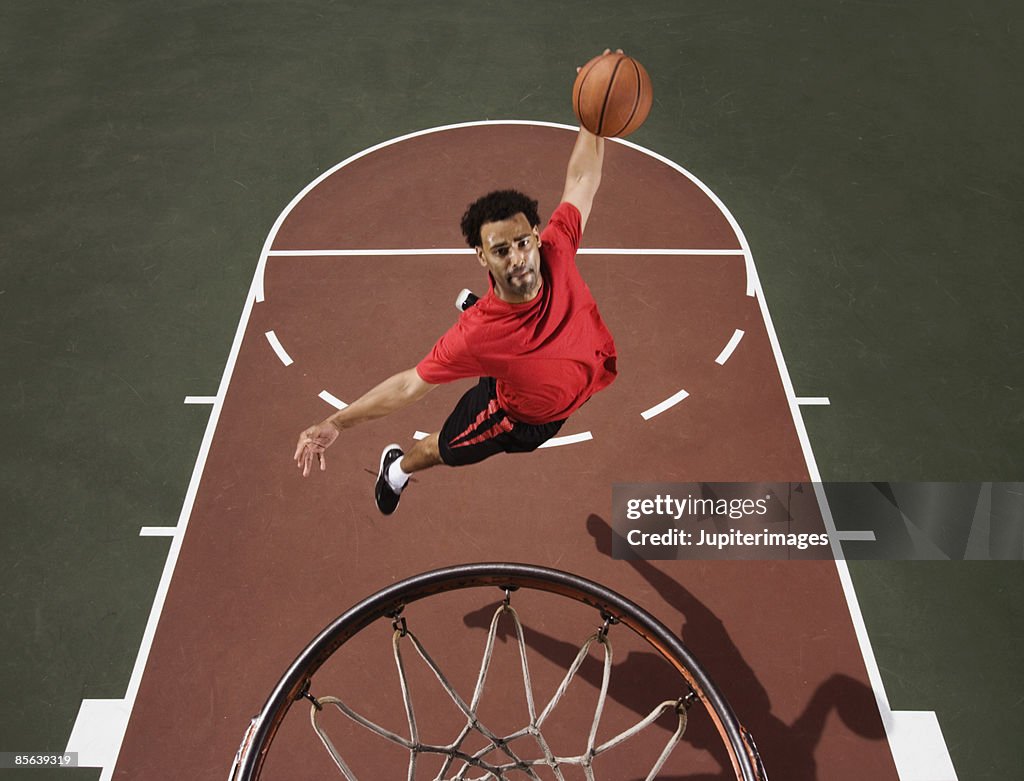 Basketball player dunking basketball