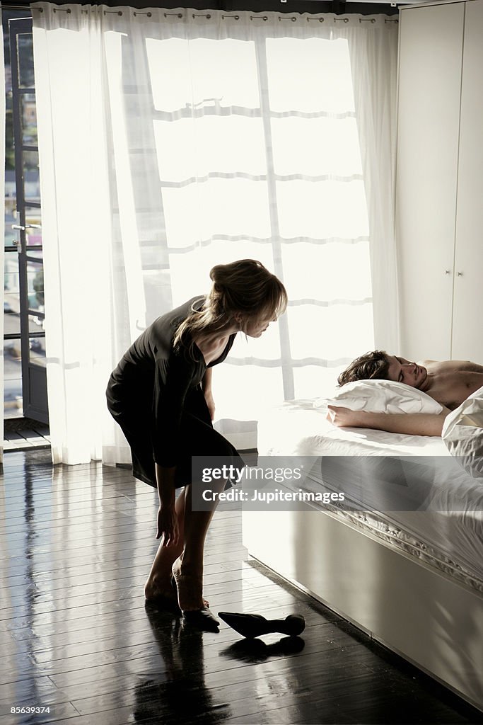 Woman trying to sneak out of bedroom