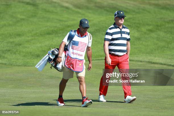 Charley Hoffman of the U.S. Team walks across a green with caddie Brett Waldman during the Sunday singles matches at the Presidents Cup at Liberty...