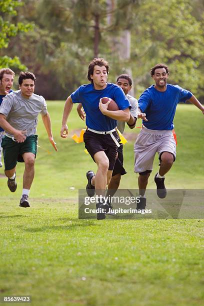 men playing flag football together - フラッグフットボール ストックフォトと画像
