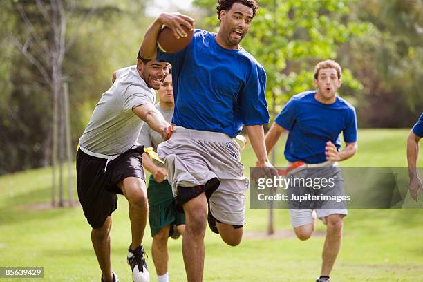 men playing flag football - flag football stock pictures, royalty-free photos & images