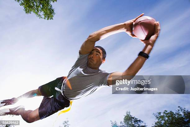 man catching football - flag football stock pictures, royalty-free photos & images