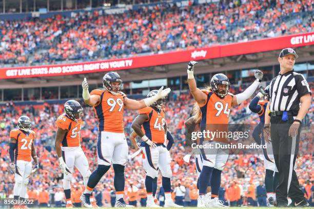 Nose tackle Domata Peko and defensive end Adam Gotsis of the Denver Broncos try to get the crowd to get loud in the second quarter of a game against...