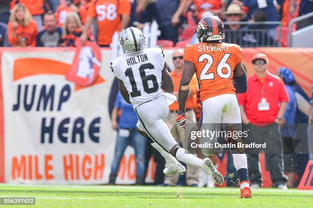 Wide receiver Johnny Holton of the Oakland Raiders, under coverage by free safety Darian Stewart of the Denver Broncos, makes a catch that would go...