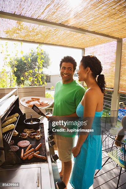 couple barbequing - couple grilling stock pictures, royalty-free photos & images