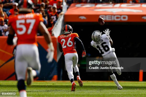 Wide receiver Johnny Holton of the Oakland Raiders, under coverage by free safety Darian Stewart of the Denver Broncos, looks over his shoulder to...