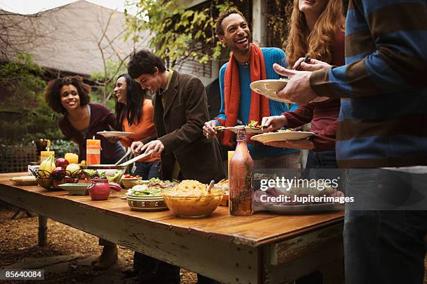 friends standing in buffet line - inviter photos et images de collection