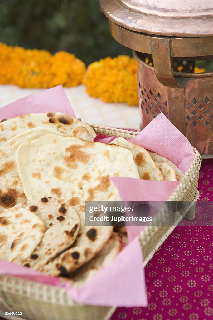 Roti and naan in basket on decorated table
