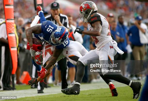 Wide receiver Brandon Marshall of the New York Giants is hit by cornerback Brent Grimes of the Tampa Bay Buccaneers during a carry in the second...