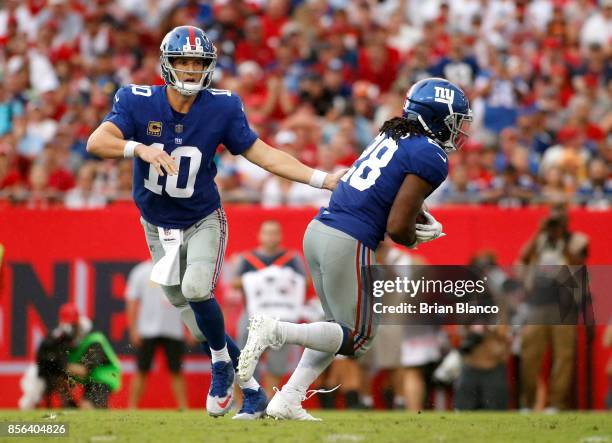 Quarterback Eli Manning of the New York Giants hands off to running back Paul Perkins during the second quarter of an NFL football game against the...