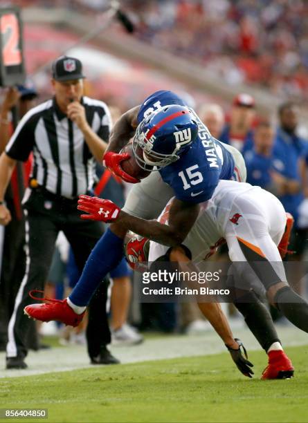 Wide receiver Brandon Marshall of the New York Giants is hit by cornerback Brent Grimes of the Tampa Bay Buccaneers during a carry in the second...