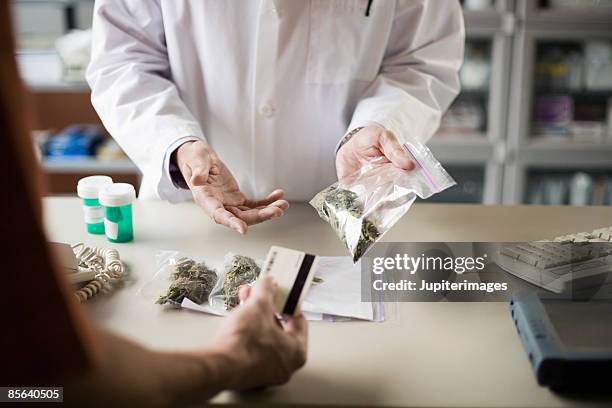 pharmacist and customer with medical marijuana - cannabis dispensary stock-fotos und bilder