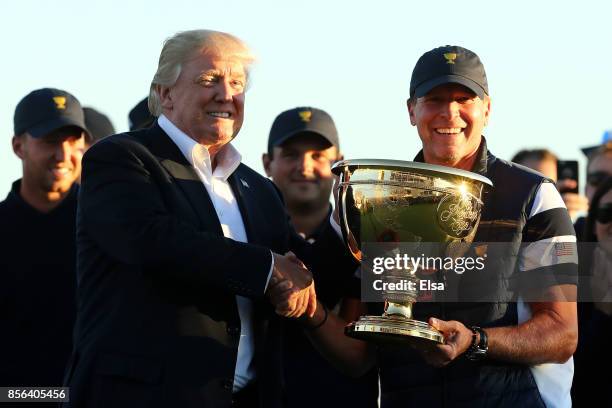 President Donald Trump presents Captain Steve Stricker and the U.S. Team with the trophy after they defeated the International Team 19 to 11 in the...