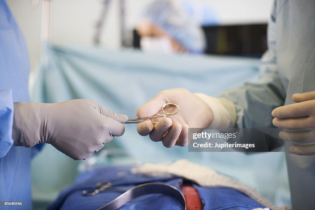 Surgeons' hands with surgical tools