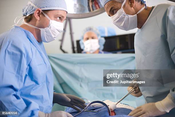 surgeons performing operation - retractor stock pictures, royalty-free photos & images