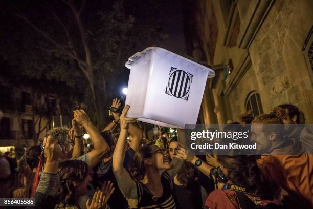 An election official carries an empty polling box out of the polling station after the counting had finished for the referendum vote on October 1,...