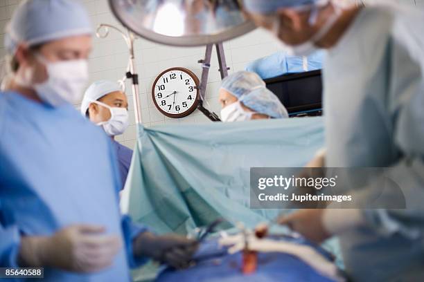 surgeons performing surgery - retractor stock pictures, royalty-free photos & images