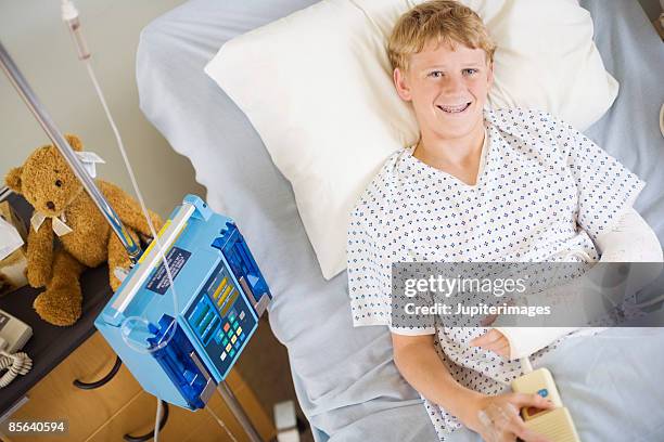 boy with broken arm in hospital bed - blonde boy braces stock pictures, royalty-free photos & images