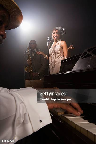singer performing with band in nightclub - piano singer stock pictures, royalty-free photos & images