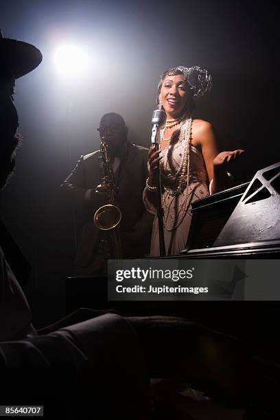 singer performing with band in nightclub - piano singer stock pictures, royalty-free photos & images