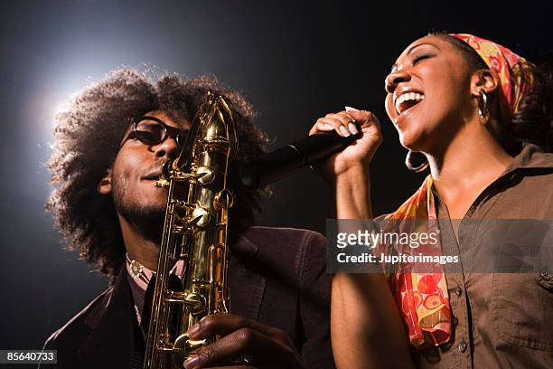 saxophone player and singer performing jazz in nightclub - 爵士樂 個照片及圖片檔