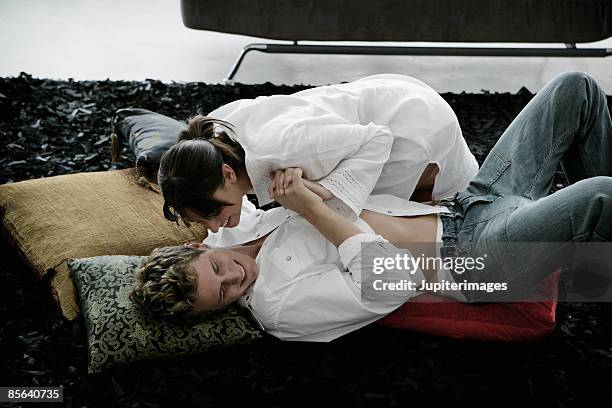 couple wrestling on the couch - spogliarsi foto e immagini stock