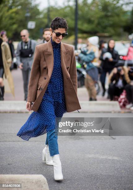 Yasmin Sewell wearing brown checked jacket, dress with dots prints, denim jeans, white boots seen outside Balenciaga during Paris Fashion Week...