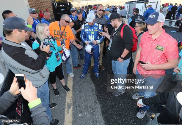 Dale Earnhardt Jr., driver of the Nationwide Chevrolet, signs autographs for fans on pit road following the Monster Energy NASCAR Cup Series Apache...