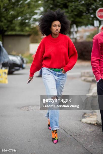 Julia Sarr Jamois wearing red knit, ripped denim jeans seen outside Balenciaga during Paris Fashion Week Spring/Summer 2018 on October 1, 2017 in...