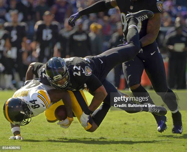 Pittsburgh Steelers wide receiver Antonio Brown bobbles a pass while Baltimore Ravens cornerback Jimmy Smith tackles, keeping the ball live for...