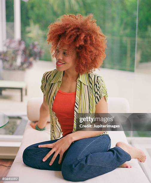 portrait of woman relaxing on chaise lounge - barefoot redhead ストックフォトと画像