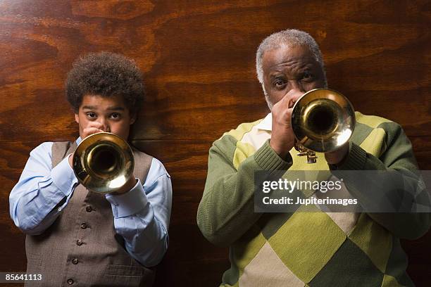 preteen boy and grandfather playing trumpets together - brass instrument stock pictures, royalty-free photos & images