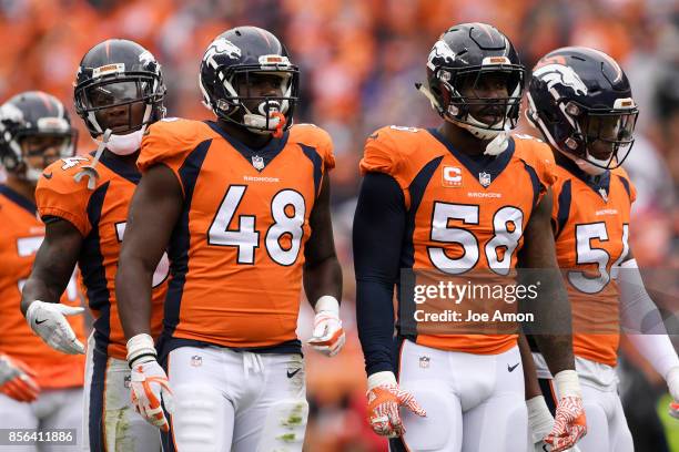 Von Miller of the Denver Broncos is flanked by defensive players Will Parks , Shaquil Barrett , Brandon Marshall during the third quarter on Sunday,...