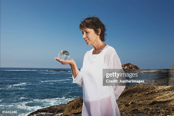 woman looking at glass ball - world philosophy day photos et images de collection