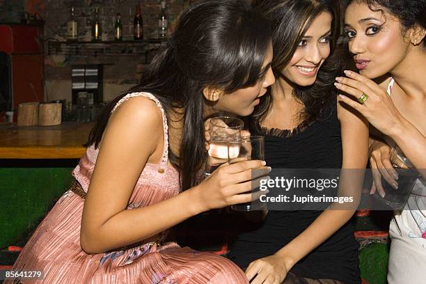 women telling secrets in nightclub - weitersagen stock-fotos und bilder