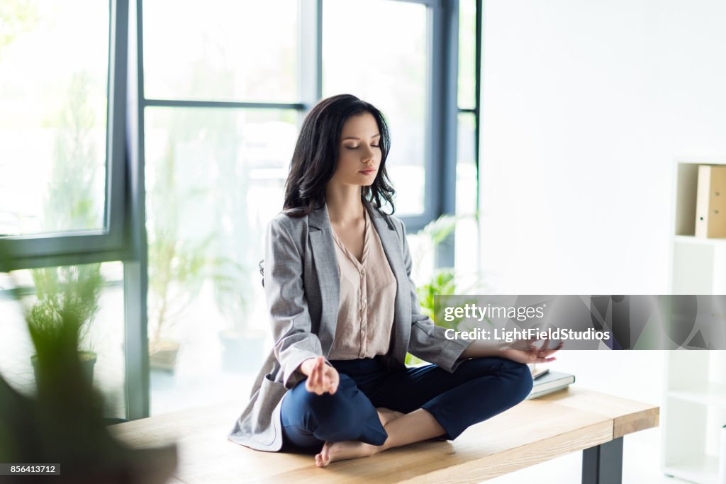 Businesswoman meditating at workplace