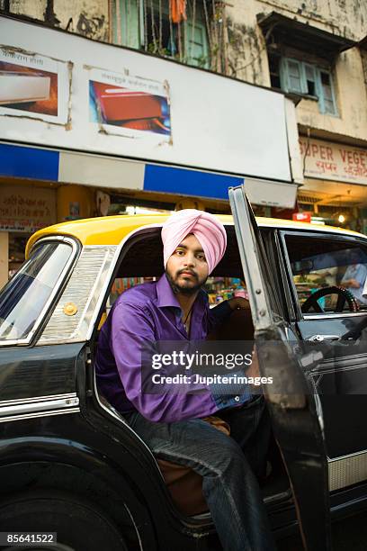 man sitting into or out of taxicab - mumbai india stock pictures, royalty-free photos & images