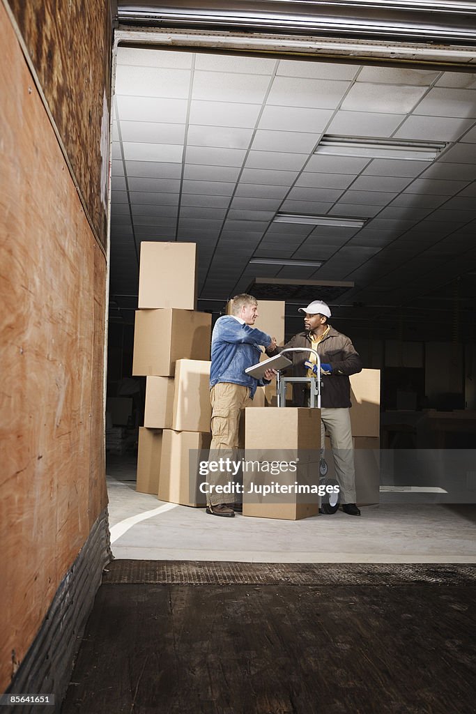 Deliveryman shaking hands with customer