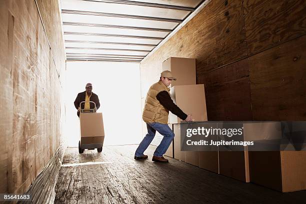 men loading boxes onto truck - lastbilstransport bildbanksfoton och bilder