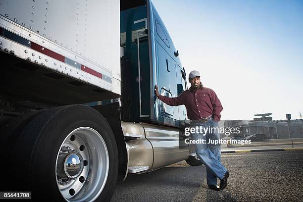 truck driver standing next to tractor trailer - african lorry stock pictures, royalty-free photos & images