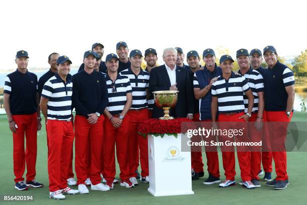 President Donald Trump poses with the U.S. Team and the trophy after they defeated the International Team 19 to 11 in the Presidents Cup at Liberty...