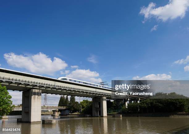 magnetic levitation (maglev) train travels at 431 km per hour through bridge shanghai, china - bullet speeding stock pictures, royalty-free photos & images