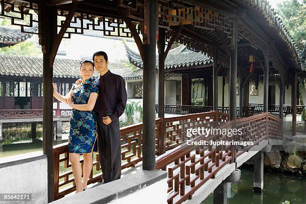 couple standing on bridge - cheongsam stockfoto's en -beelden