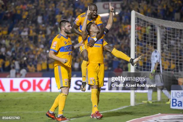 Juninho of Tigres celebrates with teammates Andre Gignac and Enner Valencia after scoring his team's winning goal via penalty during the 12th round...