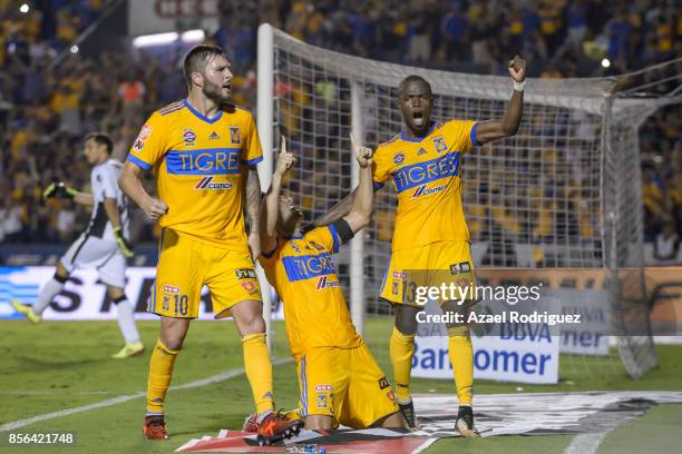 Juninho of Tigres celebrates with teammates Andre Gignac and Enner Valencia after scoring his team's winning goal via penalty during the 12th round...