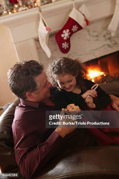 girl with man eating christmas cookie and candy cane - mint plant family stock pictures, royalty-free photos & images