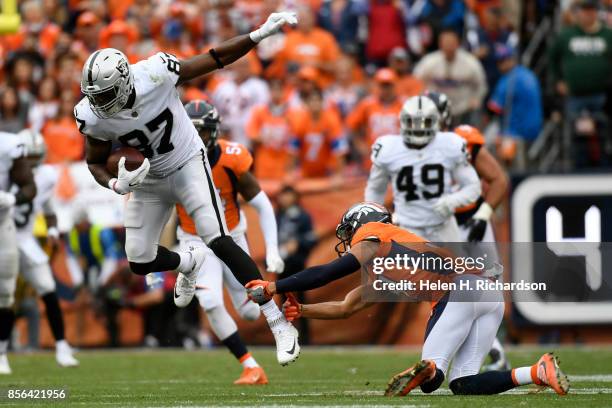 Justin Simmons of the Denver Broncos tackles Jared Cook of the Oakland Raiders during the fourth quarter on Sunday, October 1, 2017. The Denver...