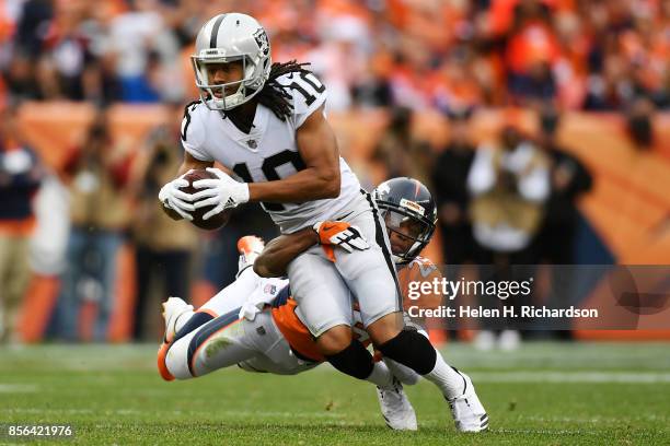 Chris Harris of the Denver Broncos tackles Seth Roberts of the Oakland Raiders during the fourth quarter on Sunday, October 1, 2017. The Denver...