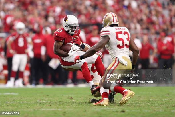 Running back Kerwynn Williams of the Arizona Cardinals is hit by defensive back K'Waun Williams and middle linebacker NaVorro Bowman of the San...