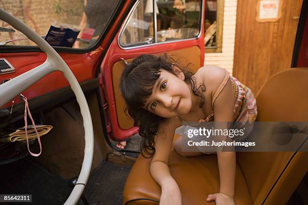 girl playing in car - classic day 4 stockfoto's en -beelden